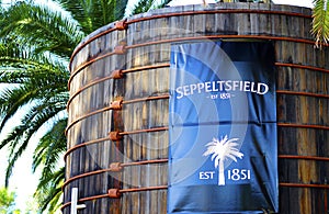 Large blue signage on old wood vats at entrance of Seppeltsfield winery.